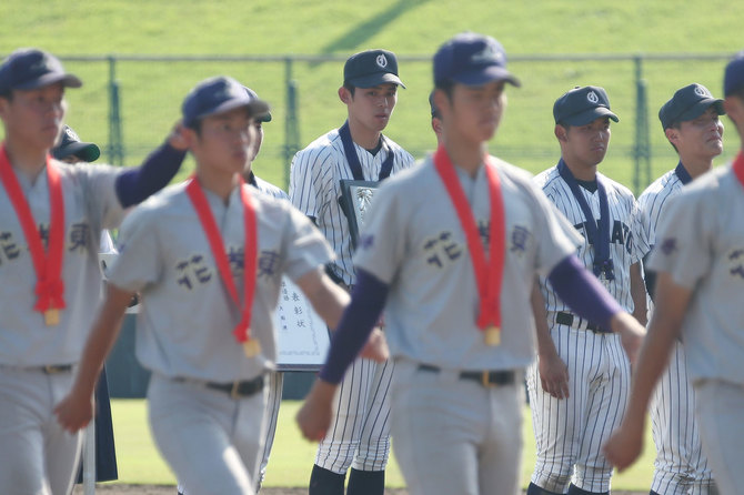 大船渡高(岩手)の国保陽平監督は163キロの速球で注目された佐々木朗希投手を、決勝戦で登板させなかったため、さまざまな議論を呼んだ。写真は岩手大会決勝・花巻東-大船渡。閉会式で行進する花巻東の選手たちを見詰める大船渡の佐々木朗希投手(中央)=7月25日、岩手県営野球場