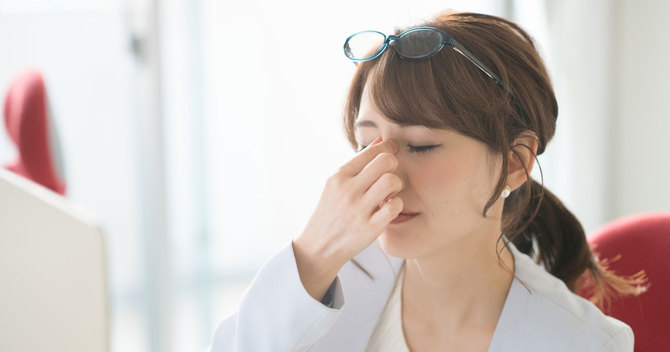 目頭を押さえる女性