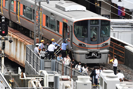 大阪北部地震で係員に誘導されて電車から避難する人々