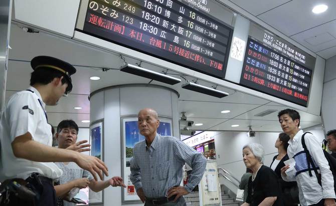 計画運休を知らせる電光掲示板と駅員