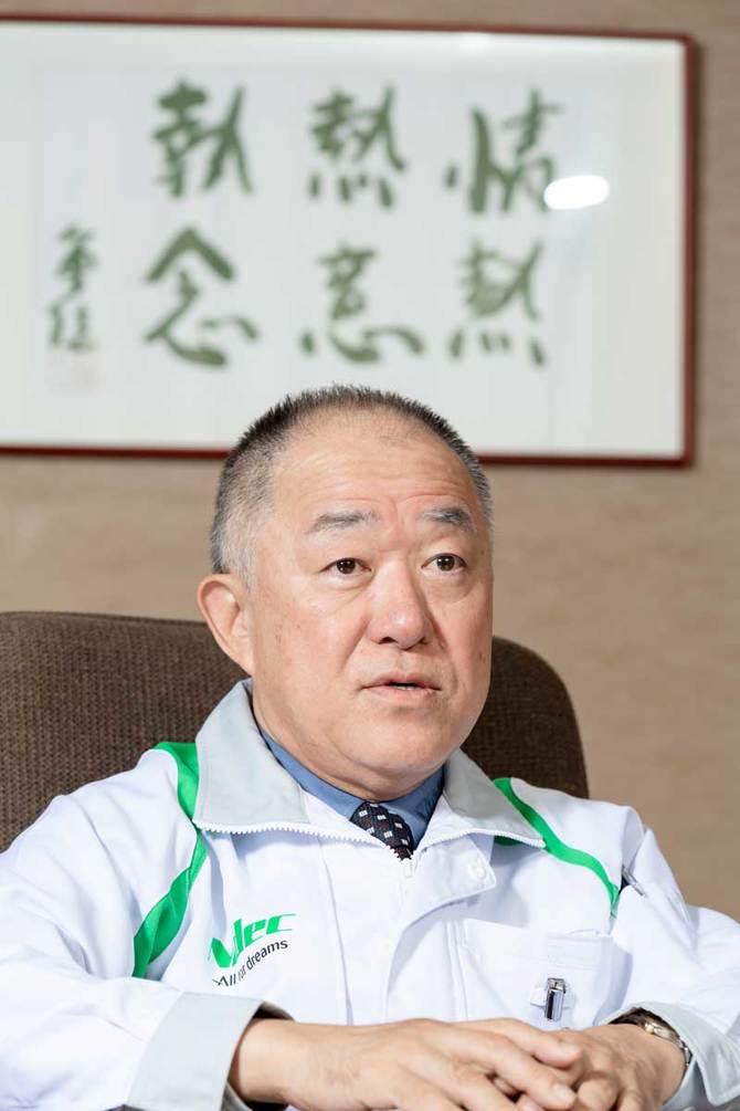 永守氏直筆の「情熱、熱意、執念」の書を背にする西本社長