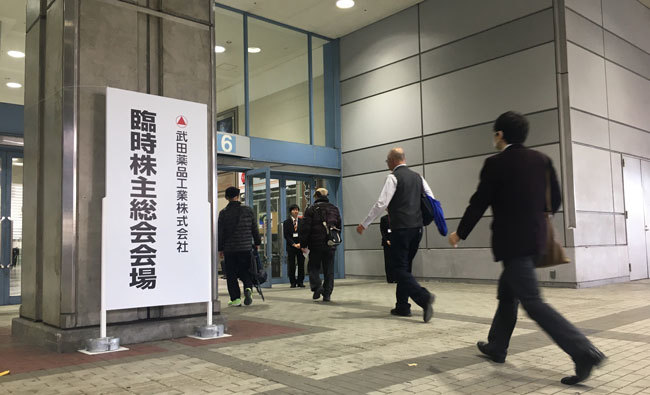 武田薬品工業の臨時株主総会。「買収完了で完全に外資系製薬会社となる」と買収反対派の株主はぼやいた